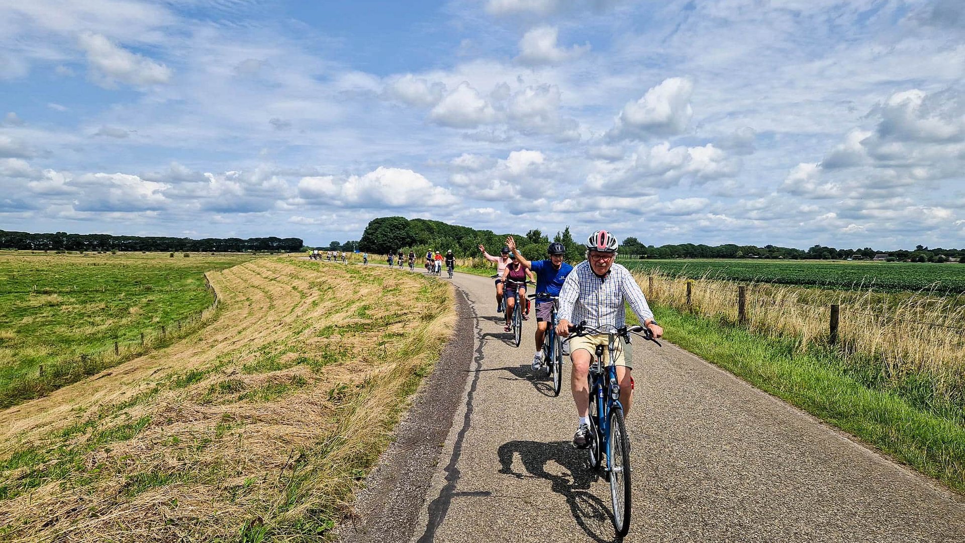Rundreise Nordholland und Friesland © Boat Bike Tours Gruppe von Radfahrern fährt auf Landstraße bei bewölktem Himmel