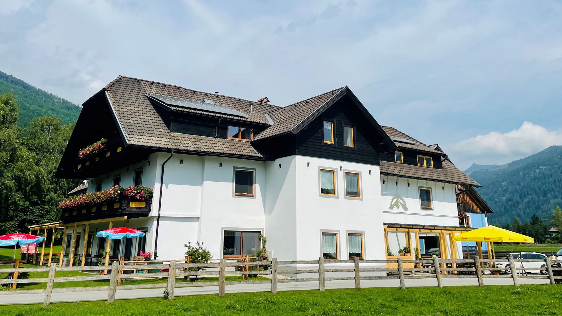 Landhaus Lungau *** © Landhaus Lungau Großes weißes Haus mit braunem Dach und Berglandschaft im Hintergrund
